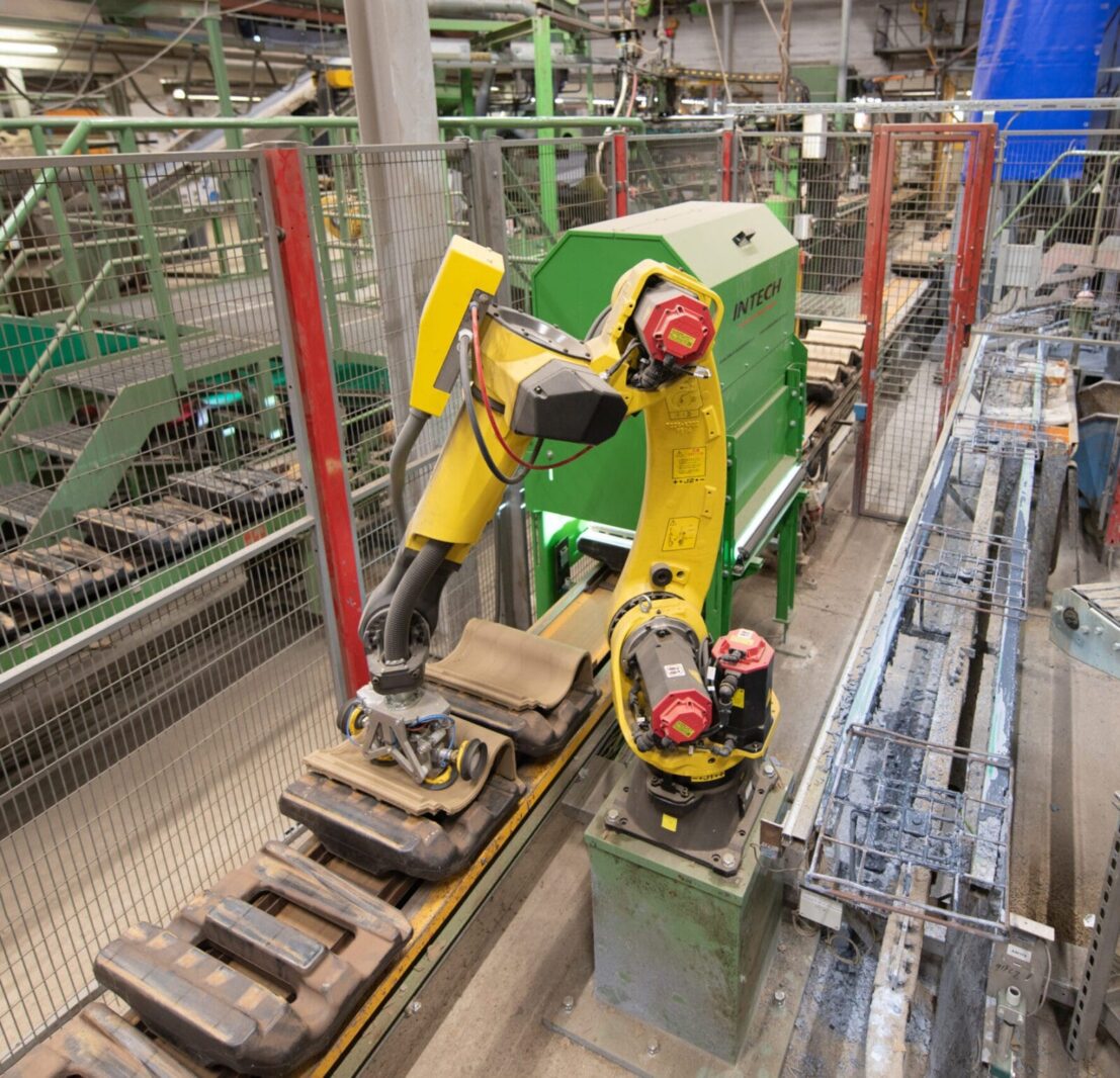 Speciaal ontworpen Robotgrijper aangestuurd door machinebesturingssysteem waarin Vision technologie is geintegreerd door Intech Installatieburo. Het vision-systeem herkent 15 verschillende modellen dakpannen en stuurt de robotgrijper aan voor exacte positionering en trefzeker oppakken van ongelijkvormige en breukgevoelige producten.